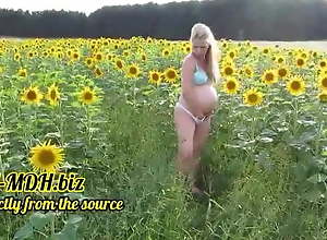 Pregnant blonde gets cum on her belly in a field